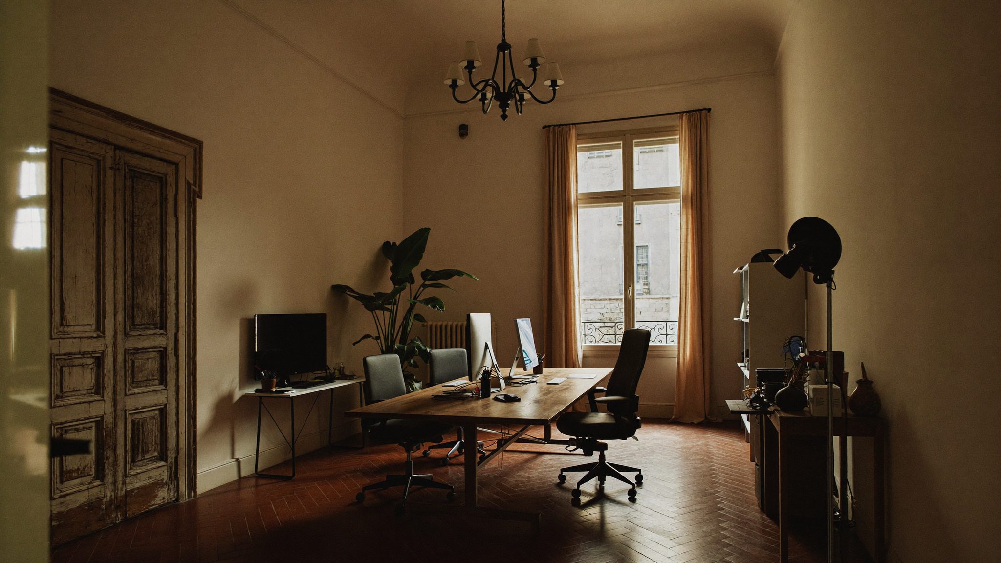 Interior do estúdio da Novtatis na Baixa de Coimbra, com secretárias, luz natural e janela para a rua